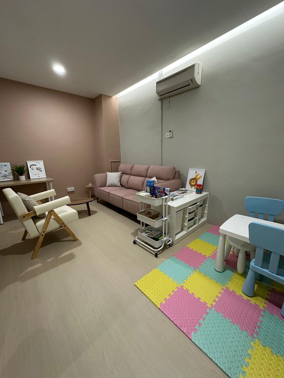 The Family Room play corner, with a small table, children’s chairs and a foam play mat beside the sofa