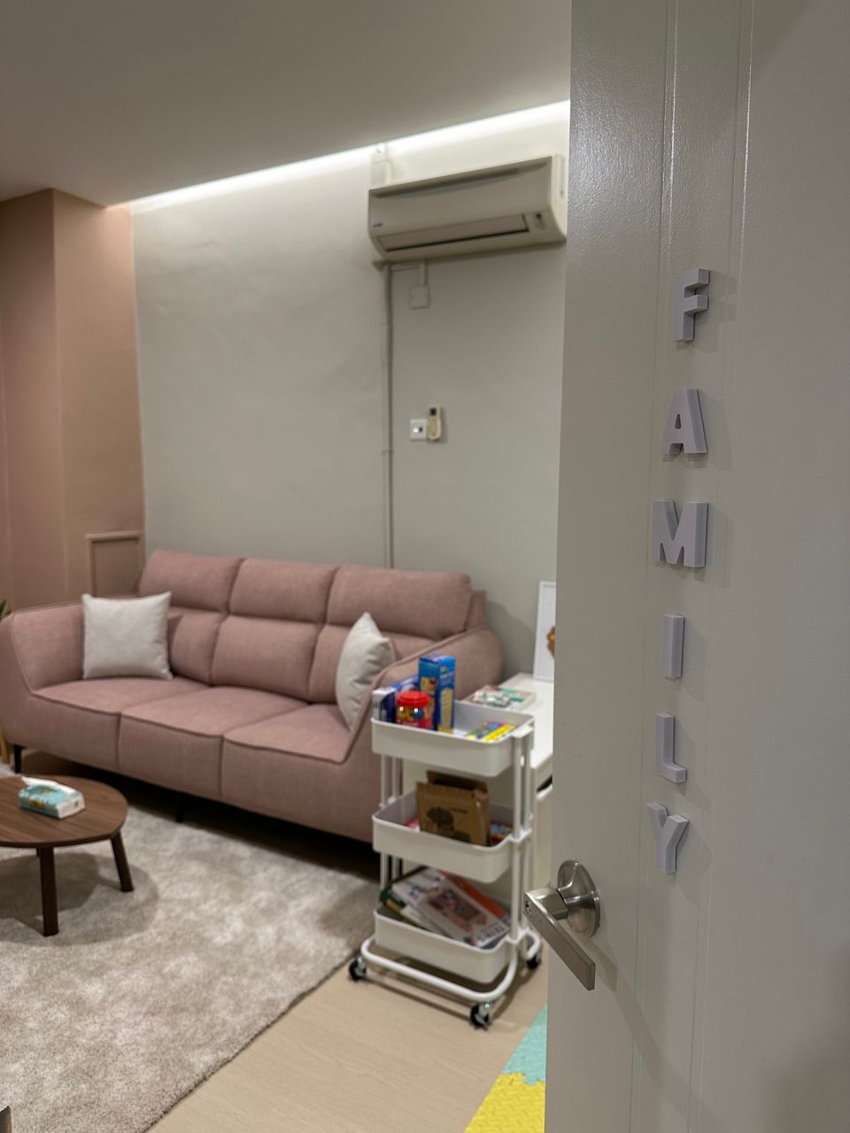 The Family Room door standing open, FAMILY lettered down the door, the pink sofa beyond