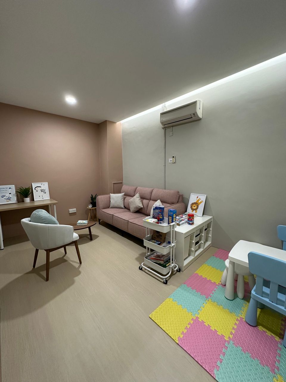 The Family Room from the door, with the sofa, a toy cart and a colourful foam play mat