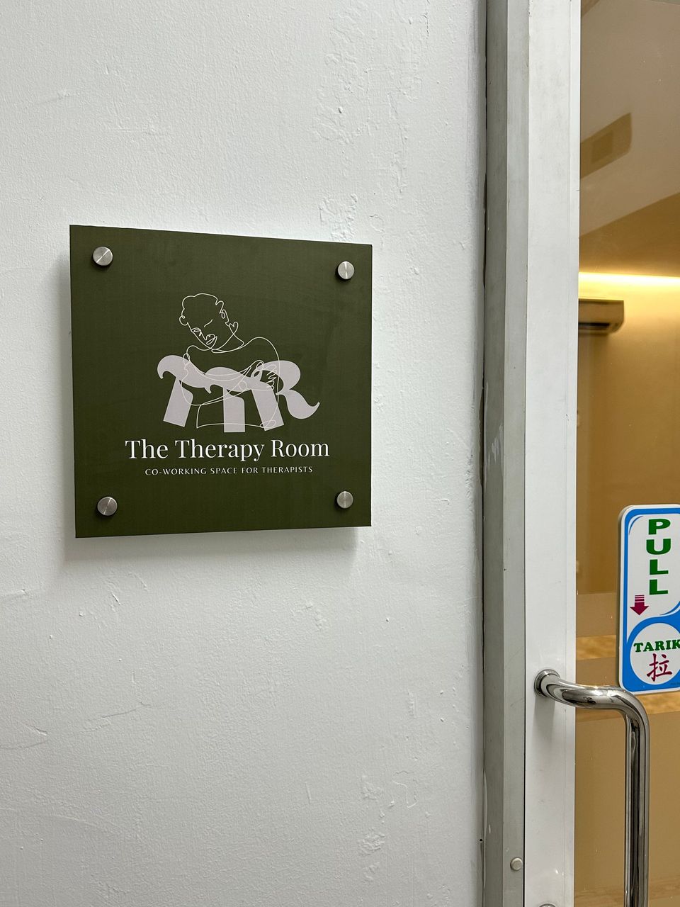 The Therapy Room logo plaque on the wall at the entrance: Co-working space for therapists